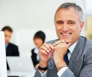 Relaunching After 50 - older business man holding glasses