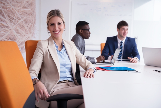 HR Trends - Professional Woman with coworkers at desk