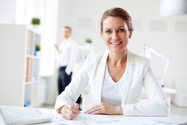Image of formal businesswoman looking at camera at workplace