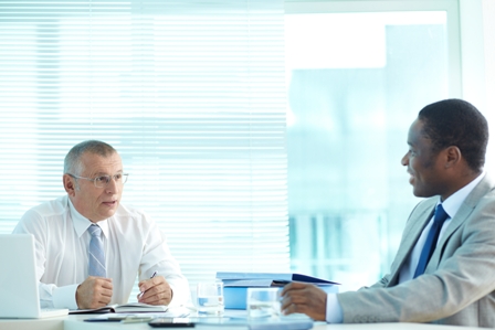 Portrait of senior boss and his employee talking at meeting