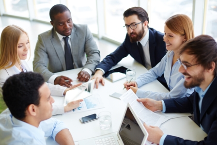 Group of business partners communicating at meeting in office