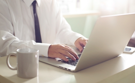 Businessman hands working on laptop,Blurred background .
