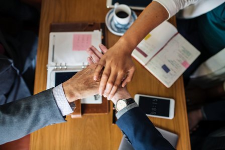 Teamwork-workers-shaking-hands-over-desk_laptops.jpg