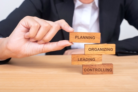 Organizational Development concept - executive placing building blocks on desk