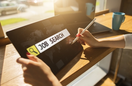 Job search concept - woman holding tablet by window
