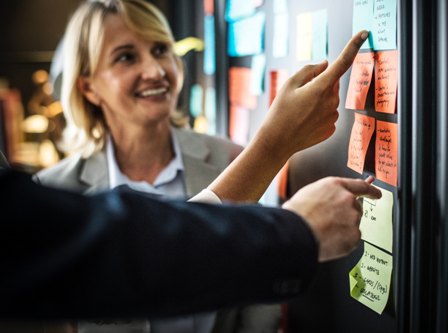 Target Company List - Woman smiling at bulletin board